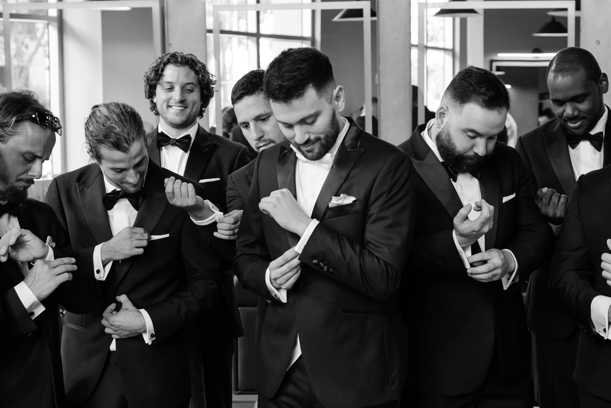 Groomsmen adjusting their cuffs in formalwear