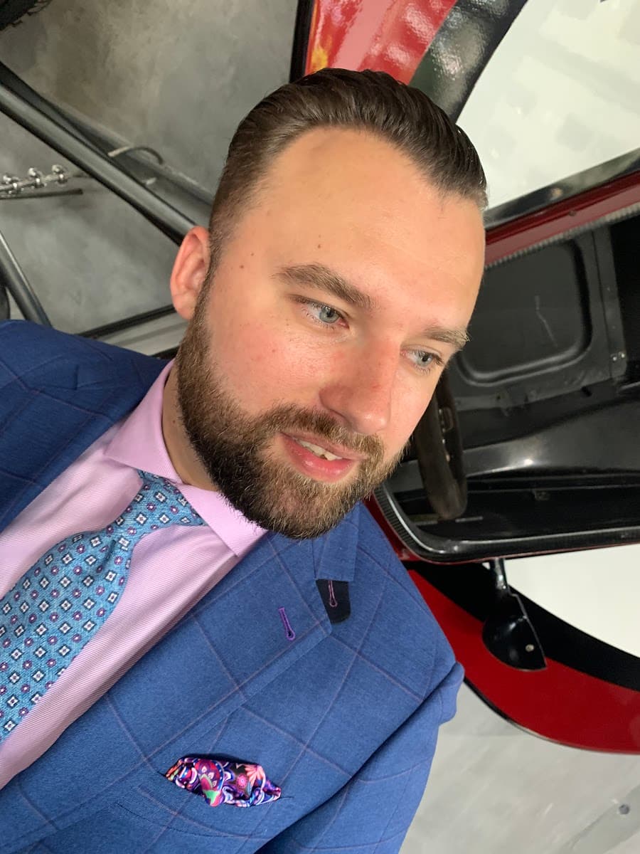 Man taking his own suit measurements for a DIY custom fit guide