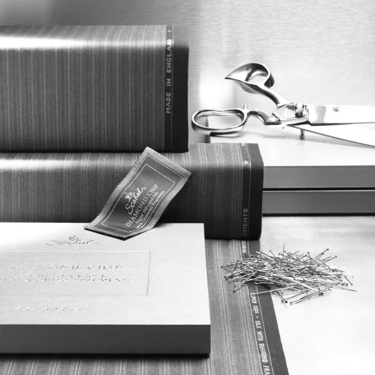 Scabal 2000 collection fabric swatches with scissors, ruler, and tailoring tools collage