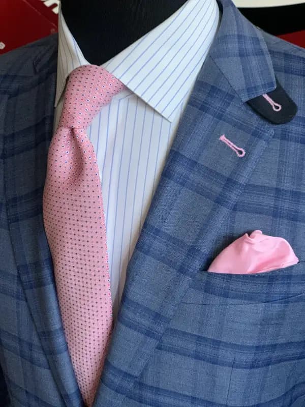 Light blue dress shirt under blue plaid sport coat with orange pocket square