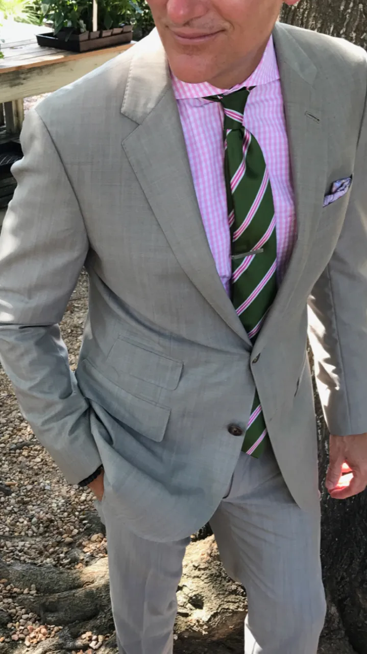 Light grey two-piece suit with pink gingham shirt and green striped tie worn outdoors by Bespoke By CB