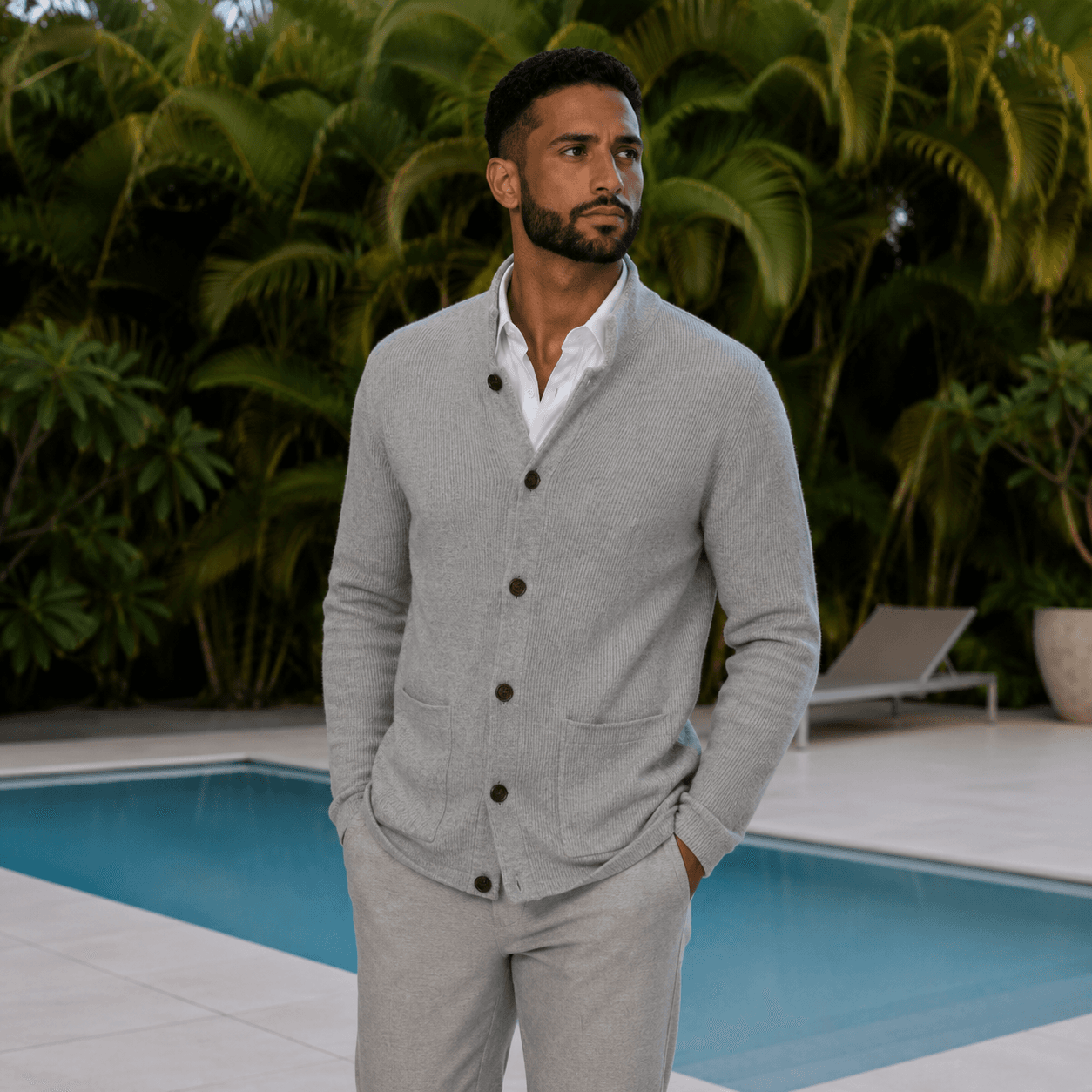 Custom heather gray knit cardigan with dark brown buttons by Bespoke By CB, worn over a white button-up shirt poolside in Miami