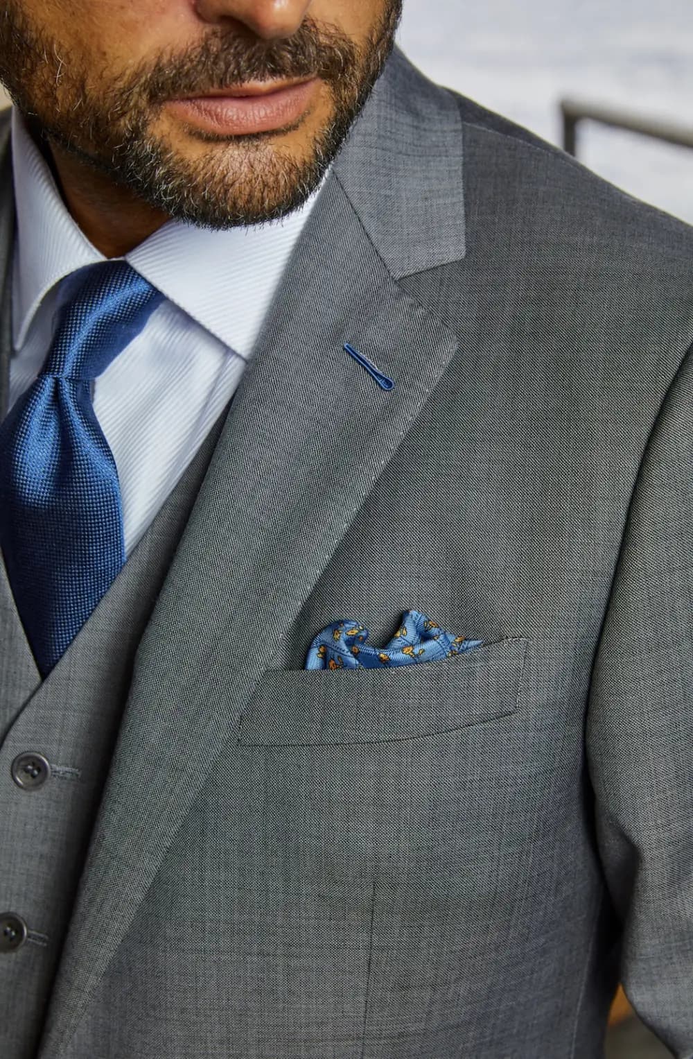 Close-up of custom suit lapel details including notch lapel, pocket square, and tie coordination from a Bespoke By CB wardrobe consultation