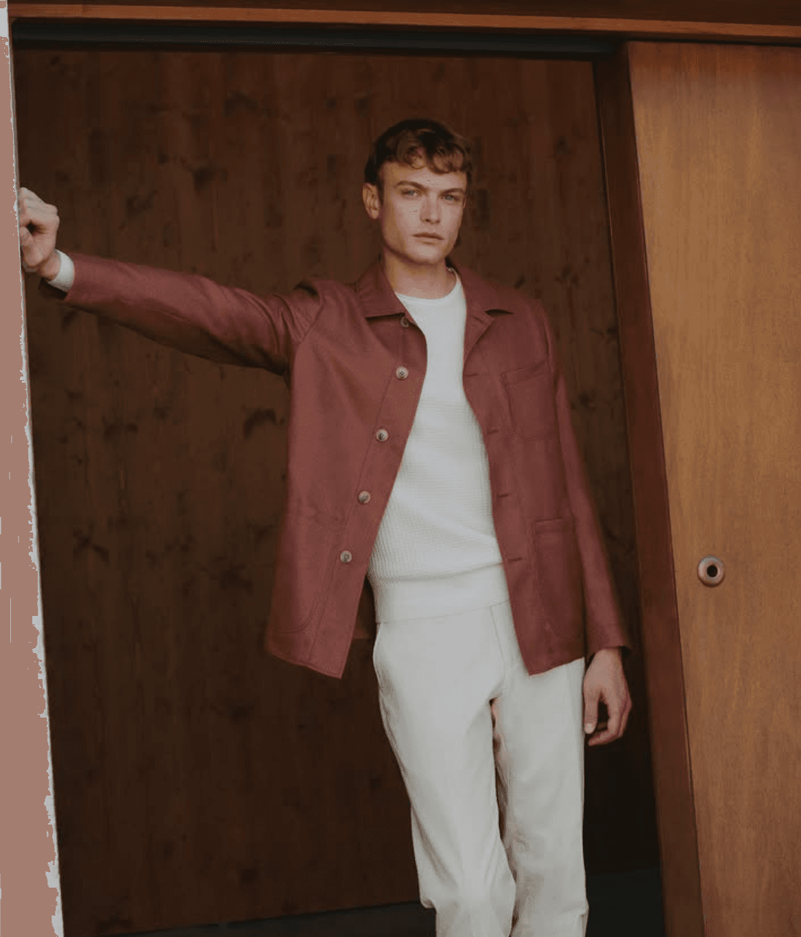 Man wearing a custom rust-colored shirt jacket over a white crew neck with cream trousers