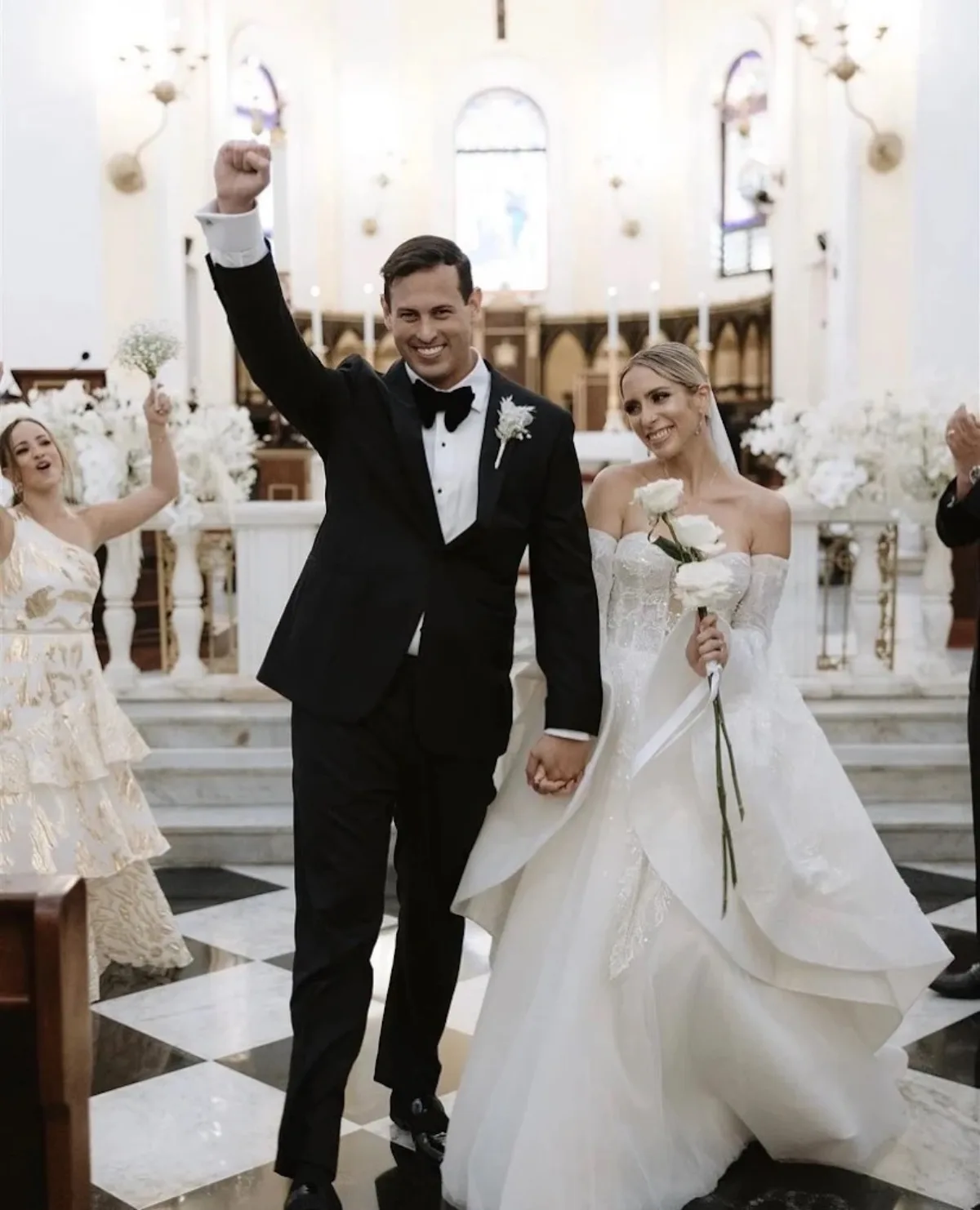 Custom black tuxedo wedding by Bespoke By CB Miami & Fort Lauderdale — groom celebrating in classic black tie
