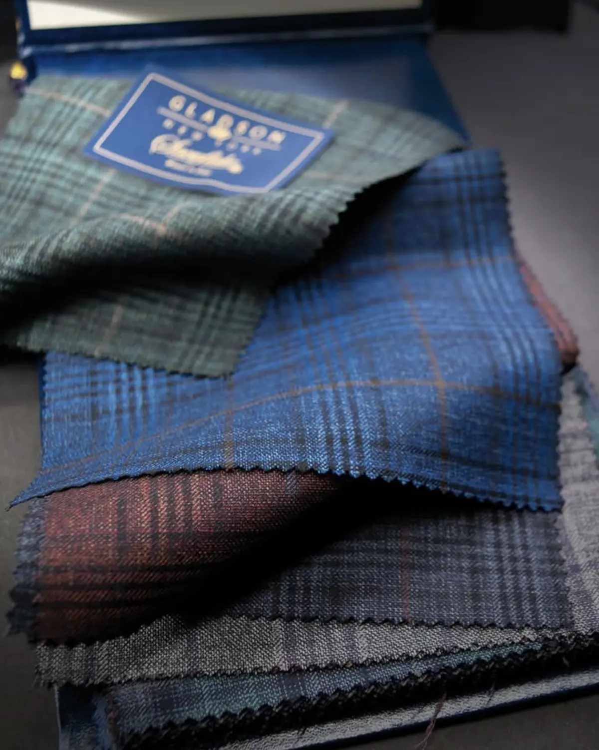 Gladson fabric swatches in plaid patterns with branded label