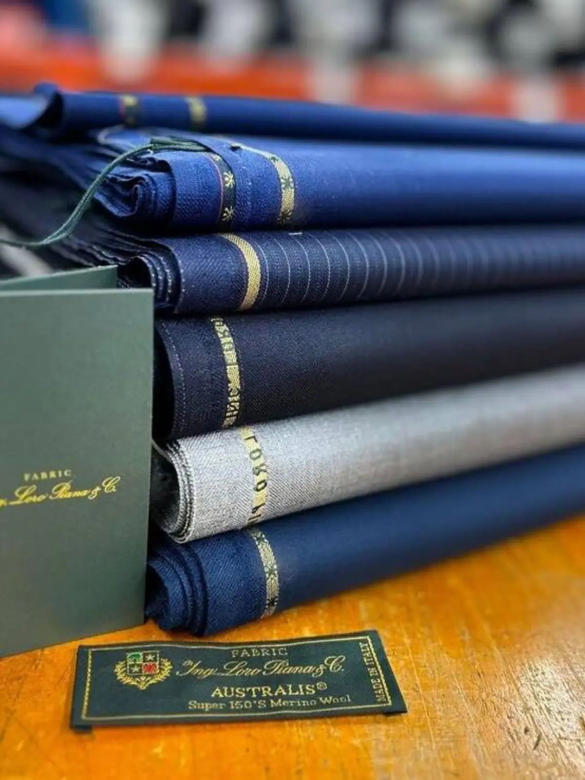 Loro Piana Australis Super 150's Merino wool fabric rolls in blue spectrum with selvedge labels