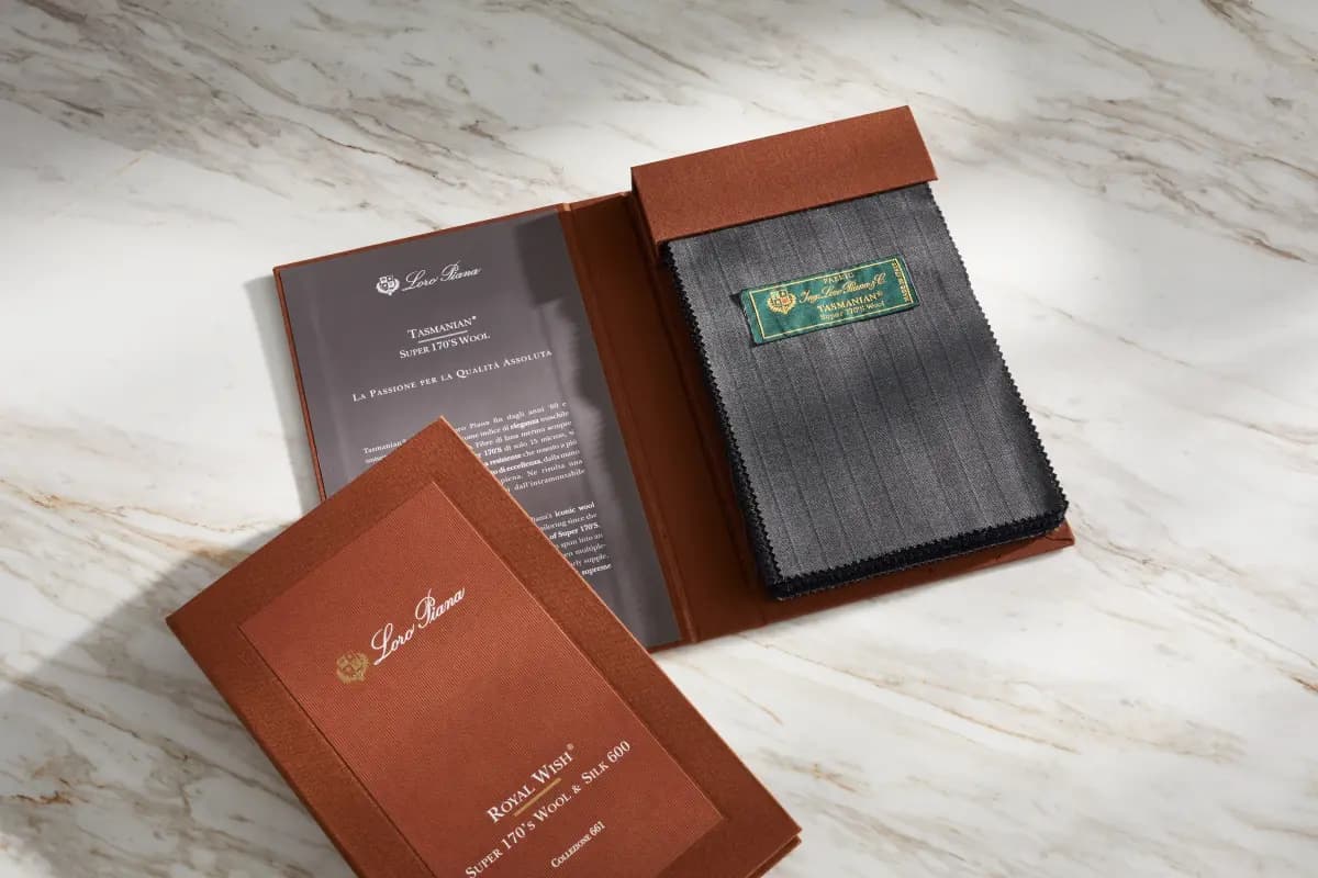 Loro Piana Tasmanian and Royal Wish swatch books on marble surface