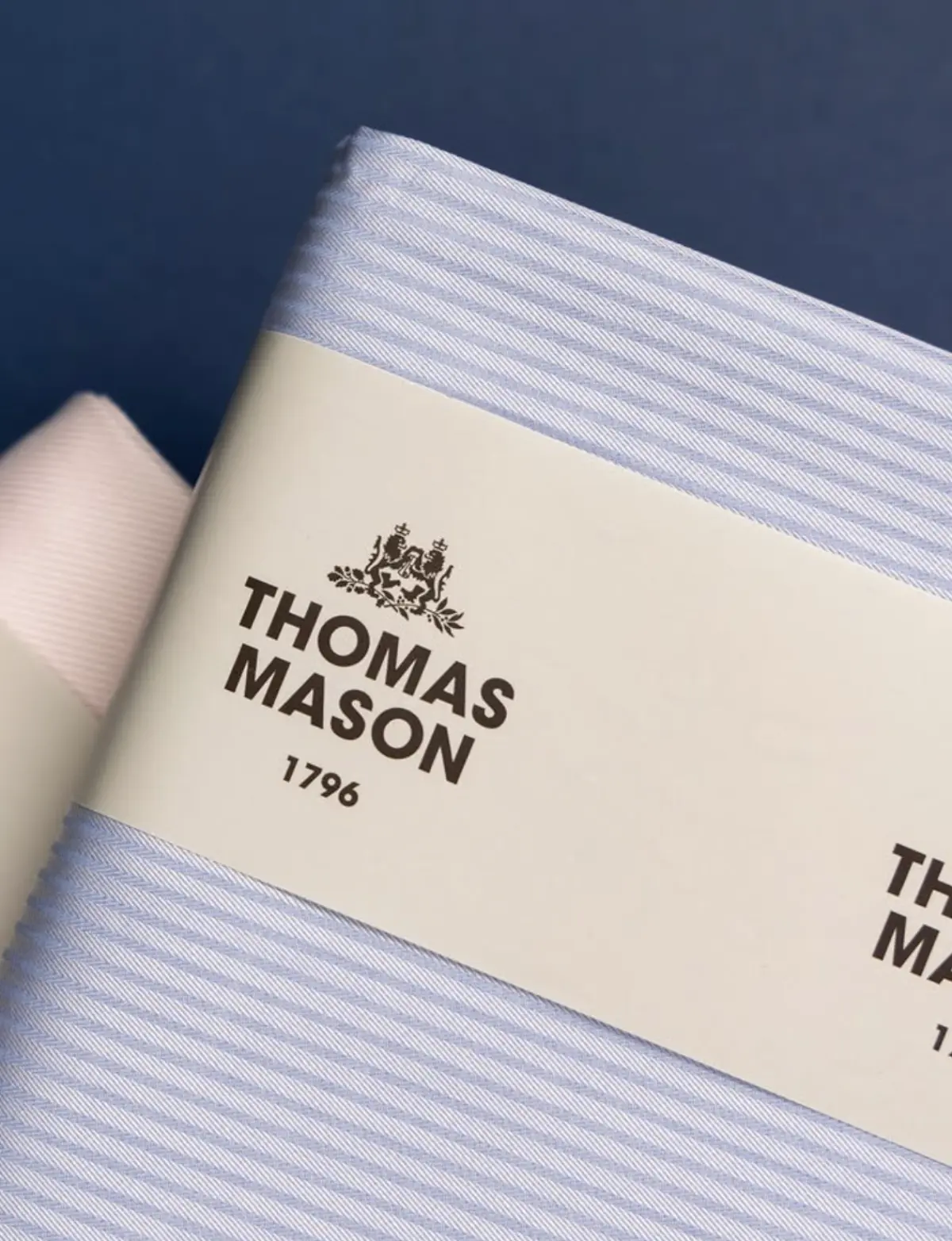 Thomas Mason 1796 fabric bolt close-up with heraldic crest and fine stripe shirt cloth