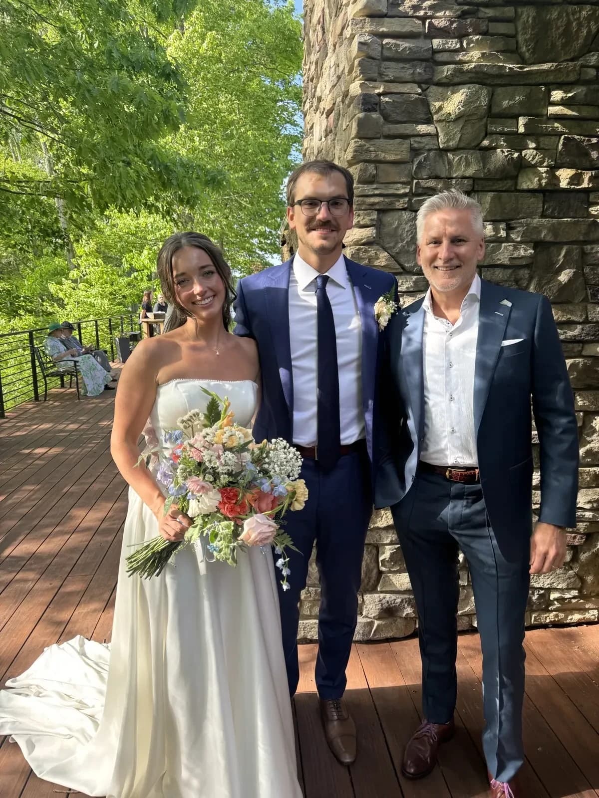 Bride with groom and father in coordinated navy tailored wedding suits by Bespoke By CB Miami