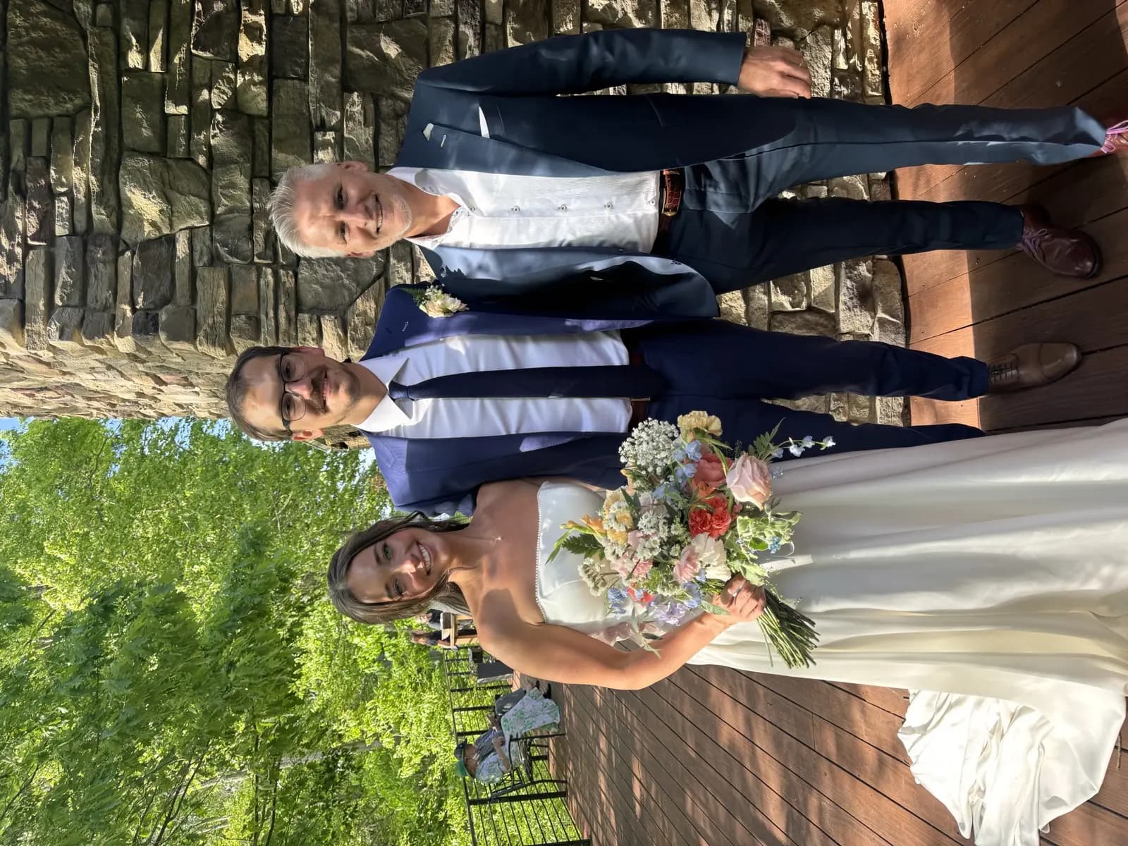 Bride with groom and father in coordinated navy tailored wedding suits by Bespoke By CB Miami