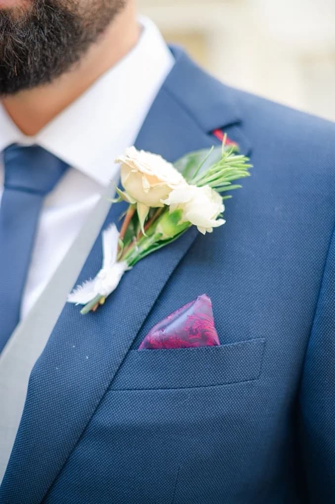 Close-up of navy wedding suit with boutonniere and pocket square by Bespoke By CB Miami