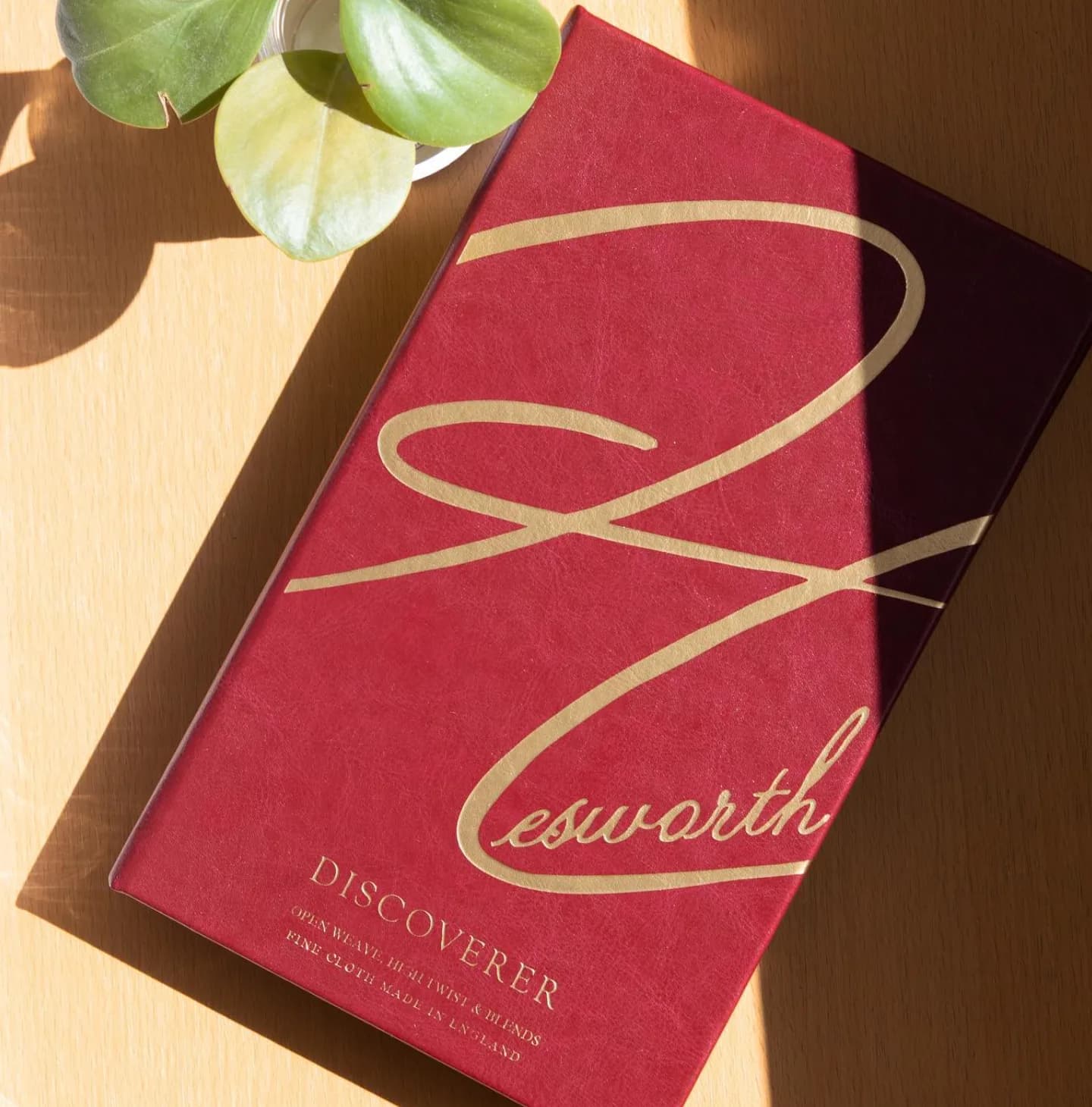 Hesworth Discoverer fabric swatch book on wooden surface with natural lighting