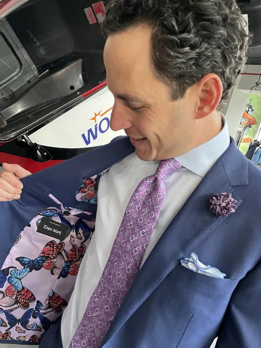 Man in periwinkle suit opening jacket to reveal butterfly-pattern custom lining, Bespoke By CB Miami